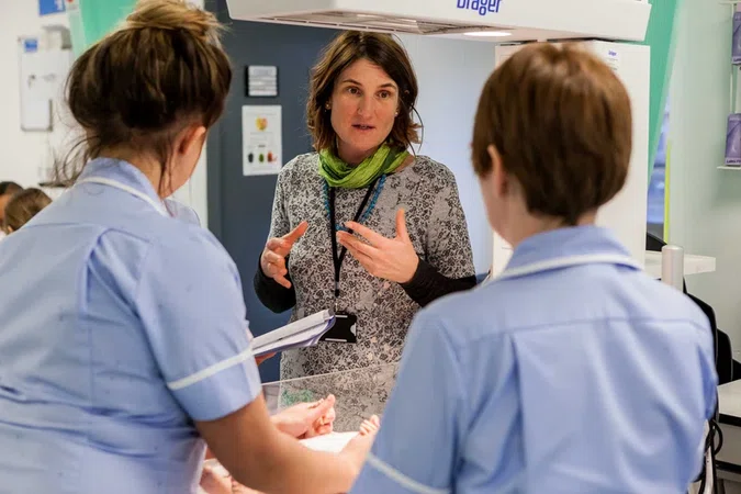 Photo showing AHP leader in discussion with nurses in midwifery unit